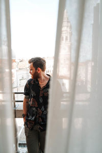 Full length of senior man standing against window