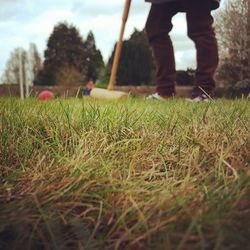 Low section of man playing with ball on grass