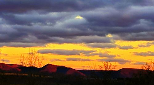 Scenic view of dramatic sky over silhouette landscape