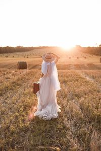 Rear view of woman standing on field