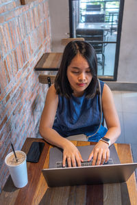 Businesswoman using laptop sitting at cafe