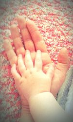 Low section of woman with baby feet on rug