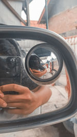 Reflection of man photographing mirror