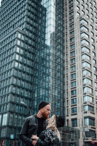 Full length of woman looking at modern building in city