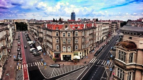 High angle view of street in city against cloudy sky