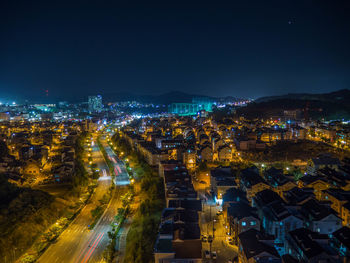 High angle view of illuminated cityscape against sky at night