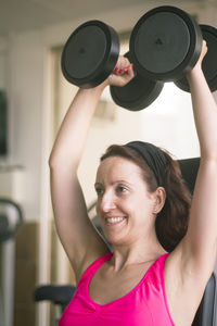 Woman doing dumbbells at happy gym