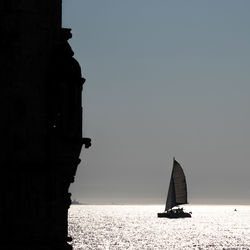 Sailboat on sea in the sunset against clear sky