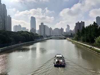 Bridge over river in city against sky