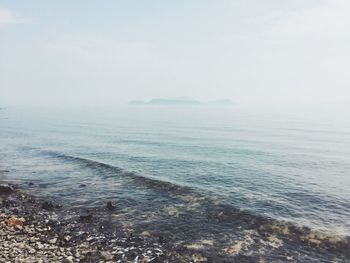 View of calm sea against sky during foggy weather