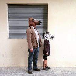 People wearing animal masks against the wall