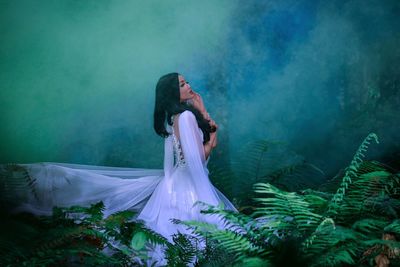 Side view of woman standing in fog