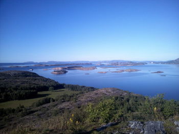 Scenic view of landscape and mountains against clear blue sky