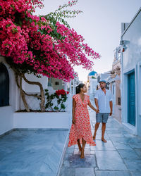 People on flowering plant against building