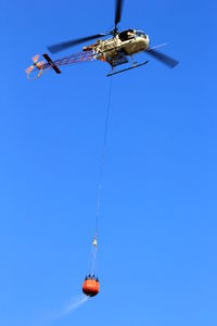 Low angle view of kite hanging against clear blue sky