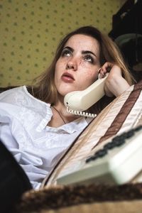 Young woman talking on telephone at home