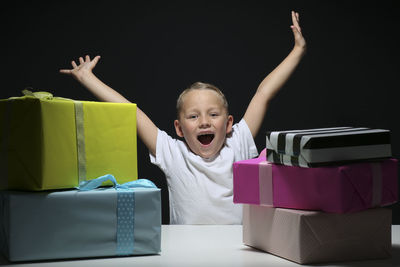 Cute girl playing in box against black background