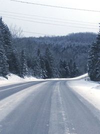 Empty road passing through snow covered landscape