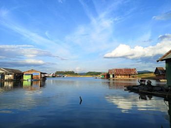 Scenic view of lake and buildings against sky