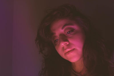 Thoughtful woman sitting in darkroom