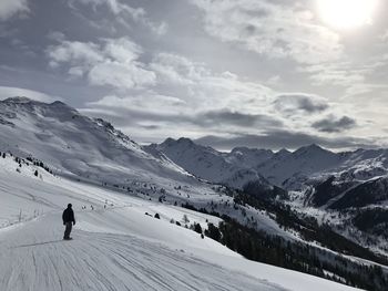 People on snowcapped mountain against sky