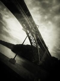 Low angle view of bridge against cloudy sky