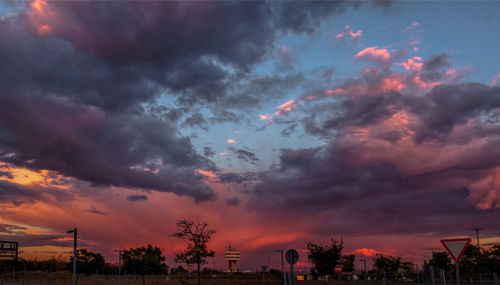 Silhouette trees against cloudy sky during sunset