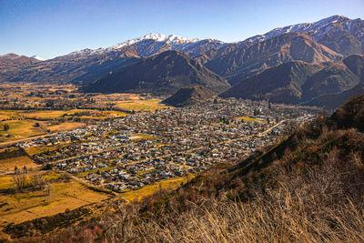 Aerial view of townscape and mountains against sky