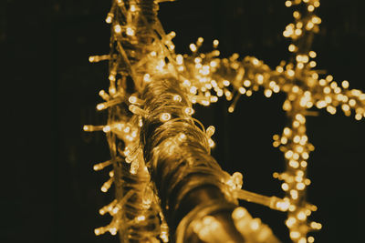 Close-up of illuminated lighting equipment against black background