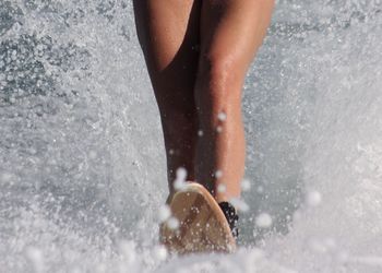 Low section of man standing in water