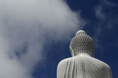 Low angle view of buddha statue against sky