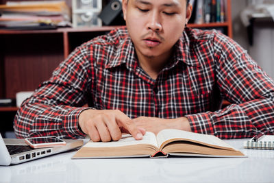 Mid adult man sitting on table