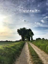 Road amidst field against sky