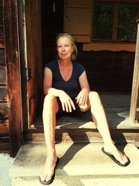 Portrait of woman sitting on doorway