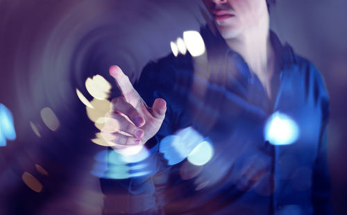 Midsection of woman touching illuminated light