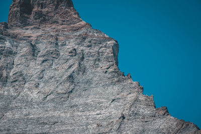 Low angle view of rock formations against clear blue sky