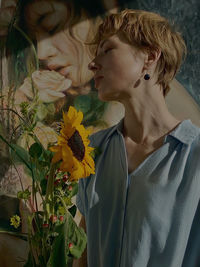 Girl standing by sunflower standing indoors