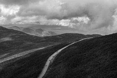 Scenic view of road leading towards mountains against sky
