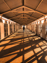 Rear view of man walking in corridor