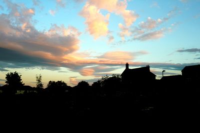 Silhouette of building against cloudy sky