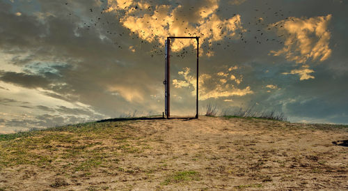 Electricity pylon on field against sky during sunset