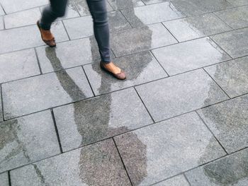 Low section of man standing on tiled floor