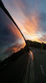 Car on street against sky at sunset