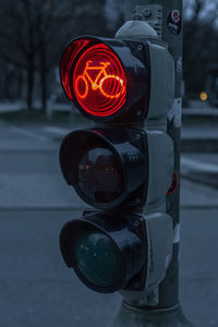 Close-up of road signal on street at dusk