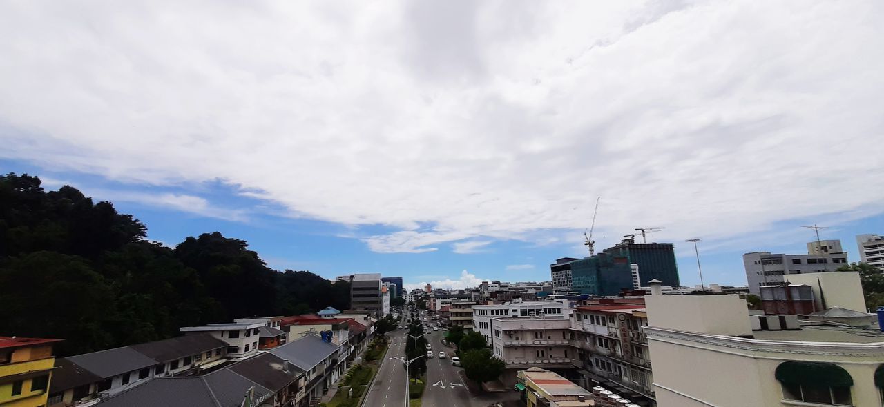 HIGH ANGLE VIEW OF BUILDINGS AND ROAD AGAINST SKY