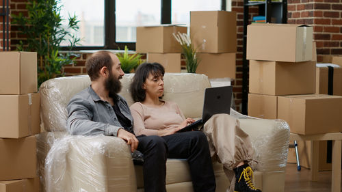 Side view of business colleagues using laptop while sitting on table