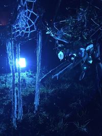 Close-up of illuminated lighting equipment against sky at night