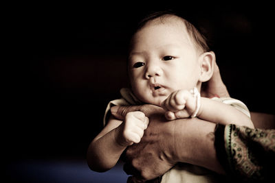 Cropped image of mother hand holding baby boy