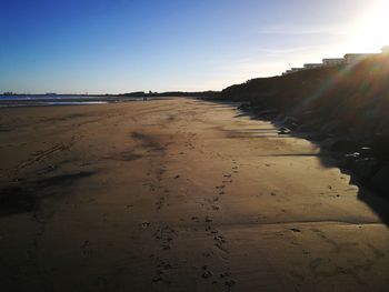 Scenic view of beach against clear sky during sunset