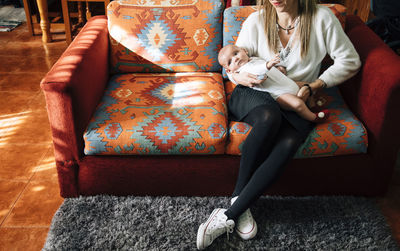 Low section of woman sitting on sofa